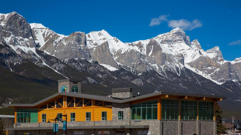 坎莫尔Canmore Downtown Hostel的一座有雪覆盖的山丘的建筑