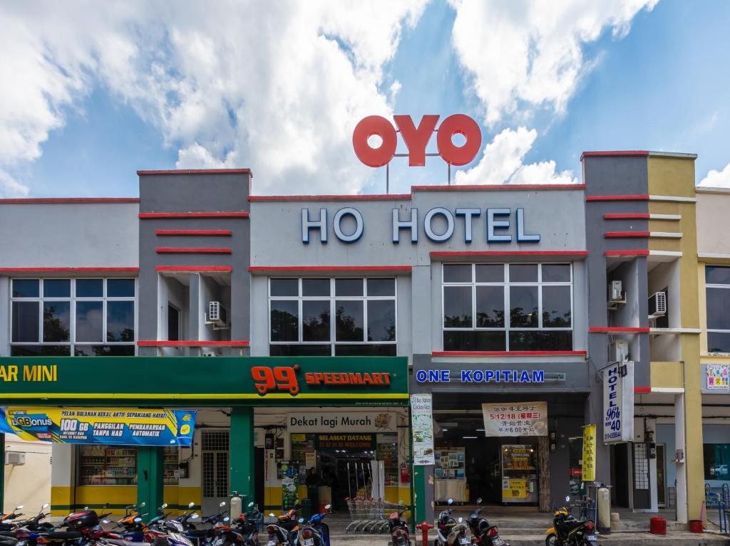 马六甲OYO 1185 Ho Hotel的一辆摩托车停在酒店前面的酒店