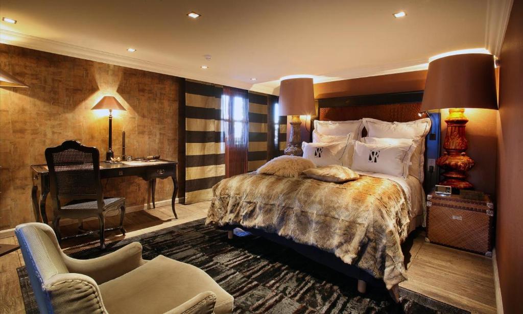 谷雪维尔Hotel Le Saint Roch的一间卧室配有一张床、一张桌子和一把椅子