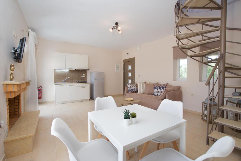 凯法利尼亚岛Rose Maisonette的厨房以及带白色桌椅的起居室。