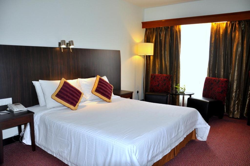 关丹关丹欧陆大酒店的酒店客房配有一张带两个枕头的大型白色床。