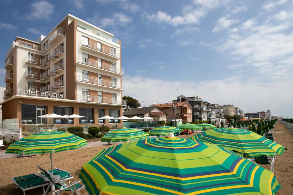 利多迪耶索罗安克拉酒店的海滩上一束遮阳伞,有一座建筑