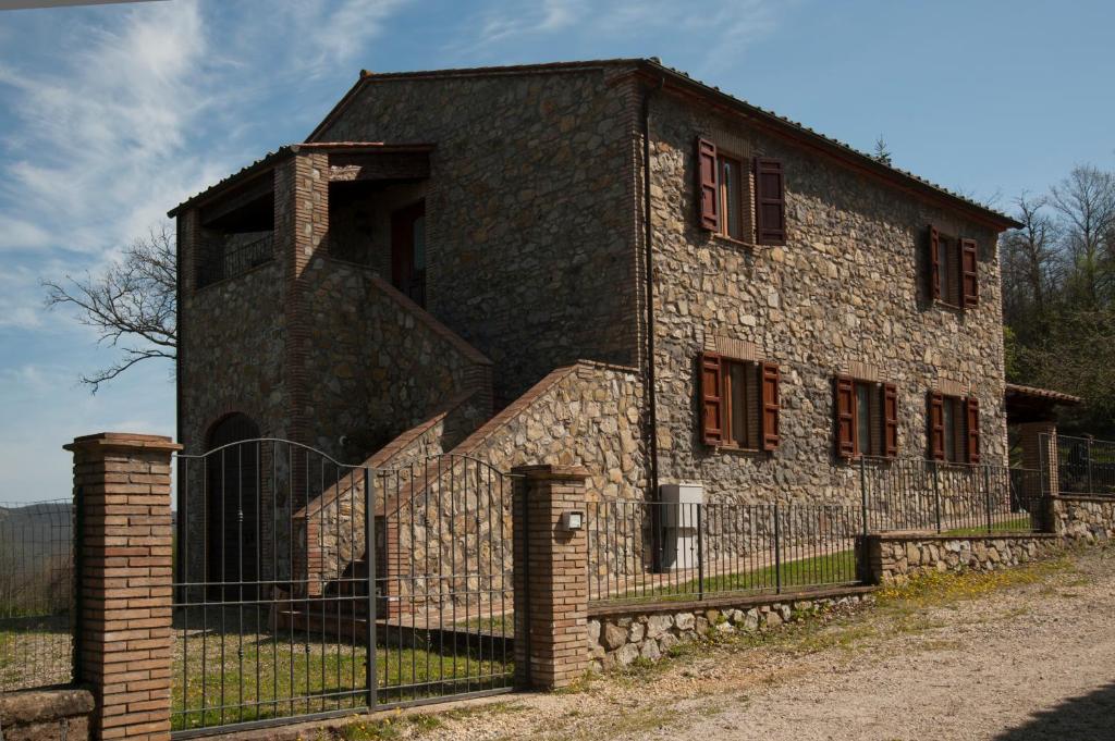 Torre AlfinaLe Querce的一座古老的石头建筑,前面有栅栏