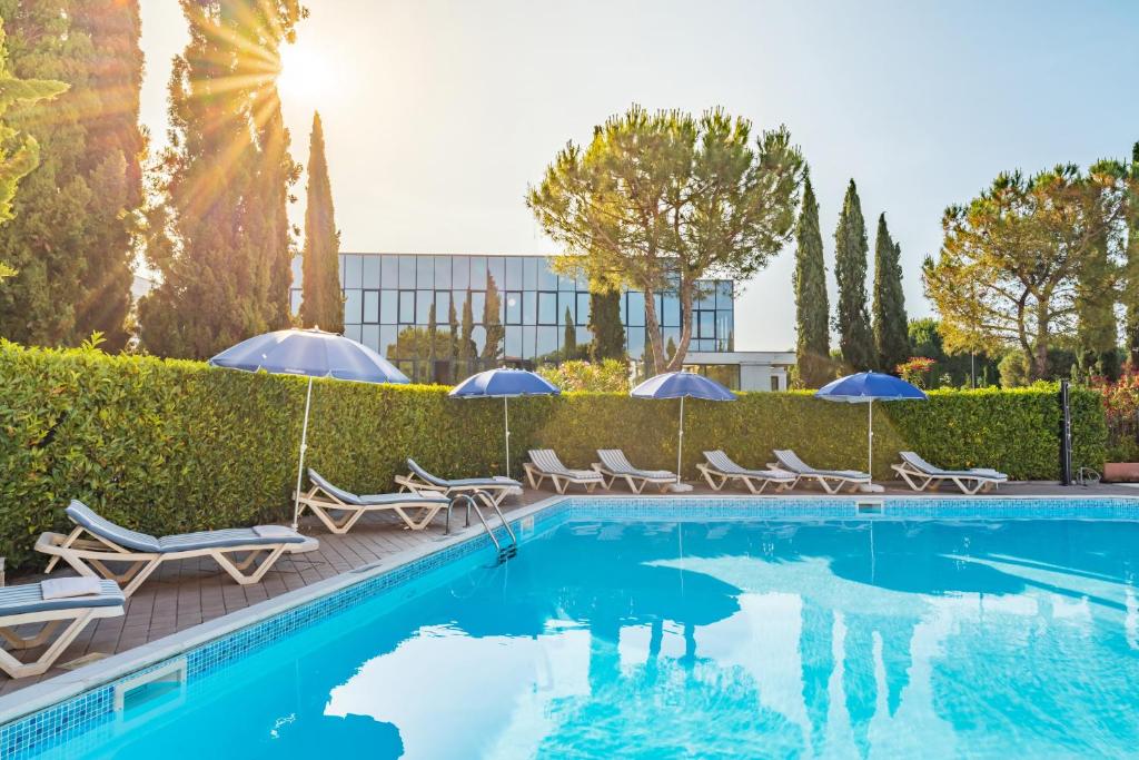 西尔米奥奈新期酒店的一个带椅子和遮阳伞的游泳池