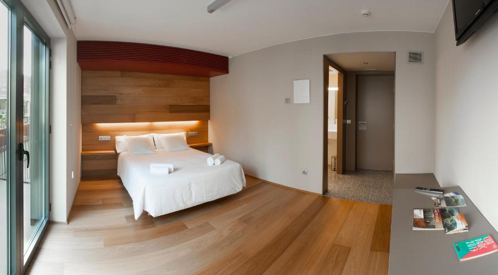奥洛特车站酒店的卧室配有白色的床和木地板