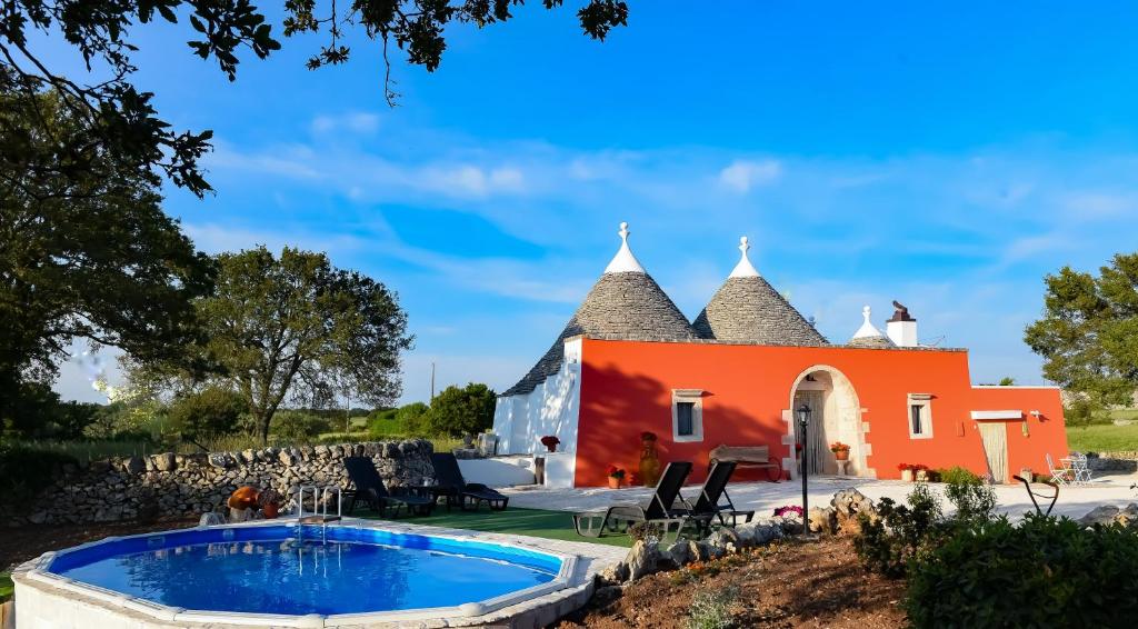 马丁纳弗兰卡Trullo Barratta的一座橙色的房子,前面设有一个游泳池