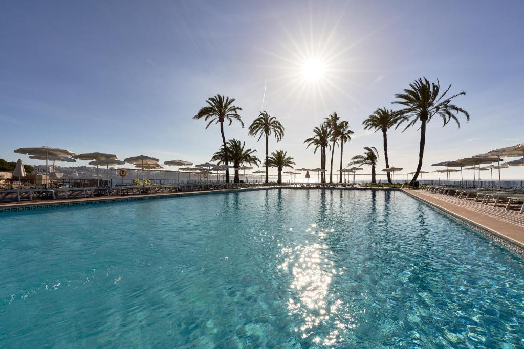 伊利塔斯Palace Bonanza Playa Resort & SPA by Olivia Hotels Collection的一座棕榈树和阳光的大型游泳池