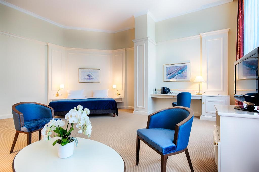 班贝格班贝格瑞贞德兹迎宾酒店的配有床、椅子和桌子的酒店客房