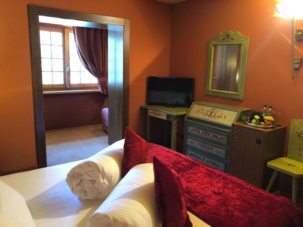布勒伊-切尔维尼亚Hotel Punta Maquignaz的一间卧室配有一张床、梳妆台和镜子
