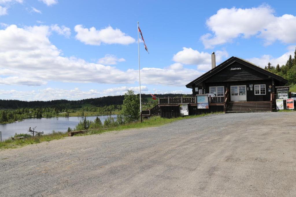 EtnedalGamlestølen Fjellstue的道路一侧有旗帜的建筑物