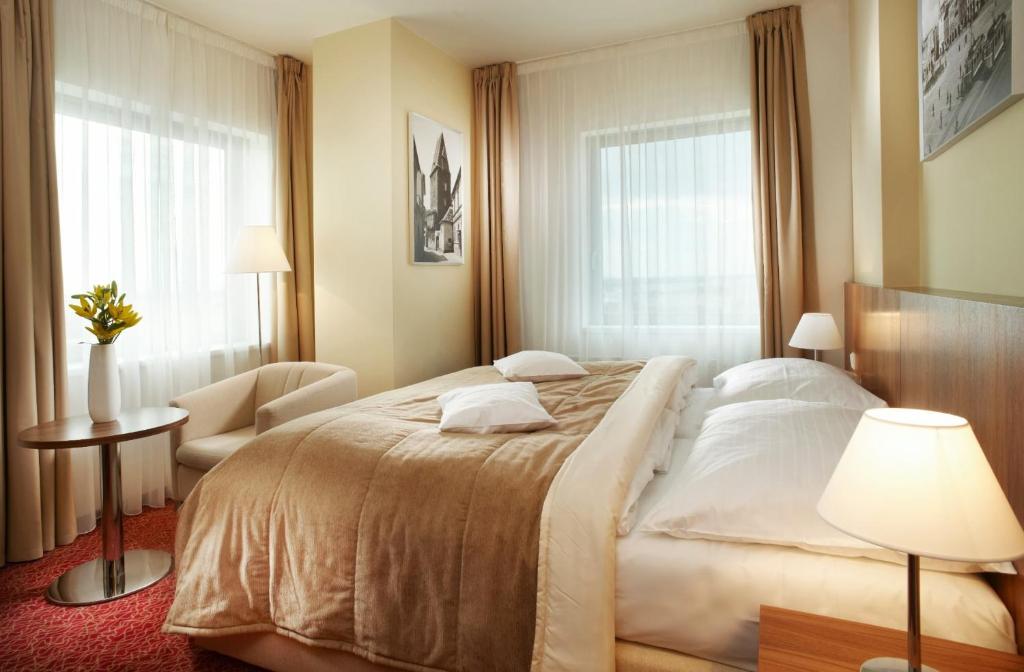 捷克布杰约维采捷克布杰约维采克拉丽奥酒店的酒店客房带一张大床和一把椅子