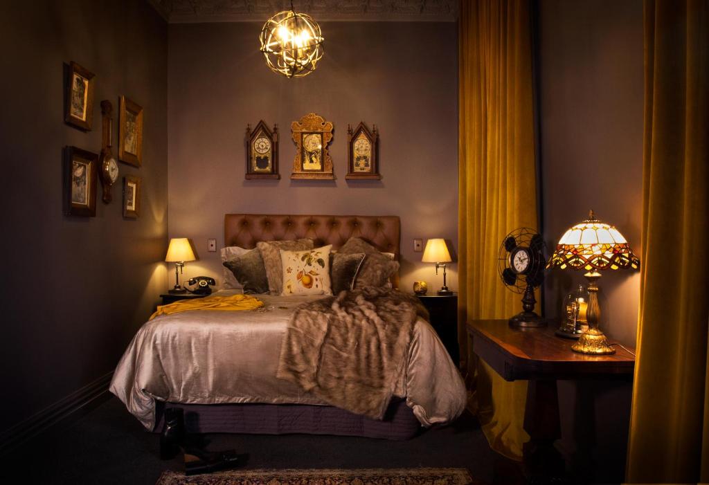 FeatherstonThe Royal Hotel Featherston - Boutique Hotel的一间卧室配有一张床、两盏灯和一张桌子。