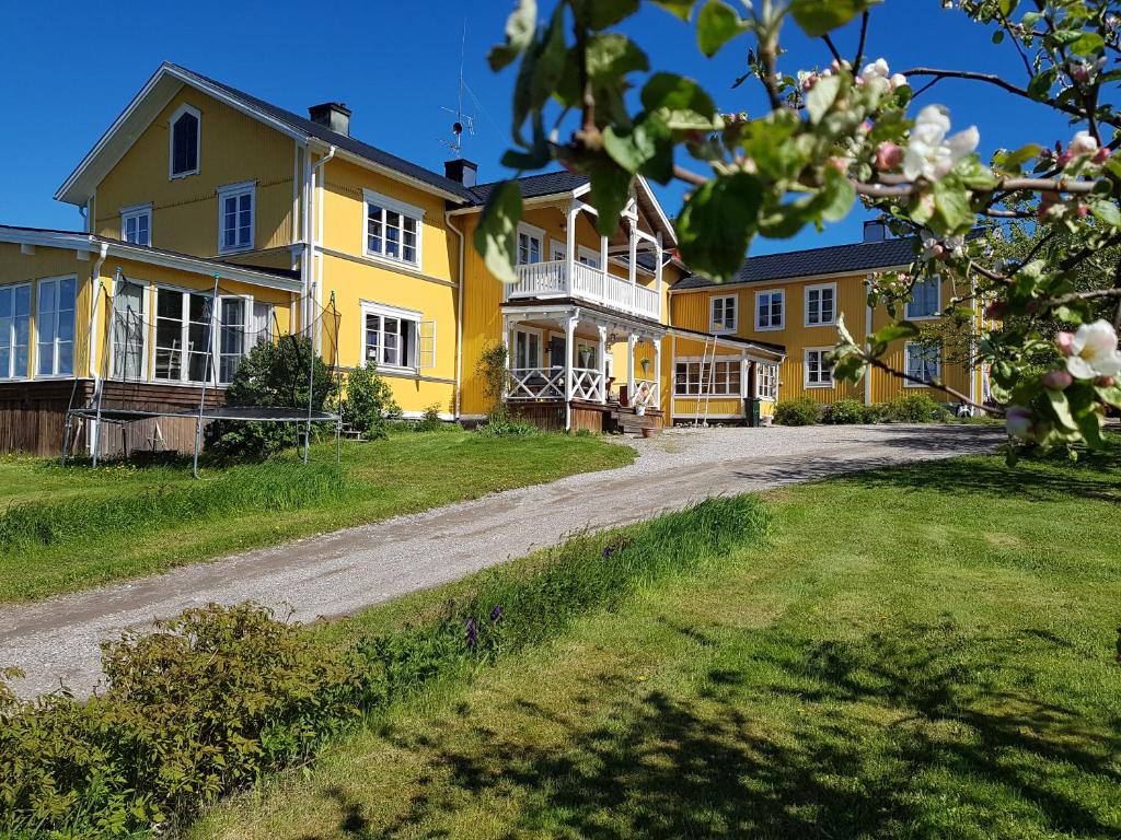 HarmångerNygården B&B Hälsingegård的一条土路的黄色大房子