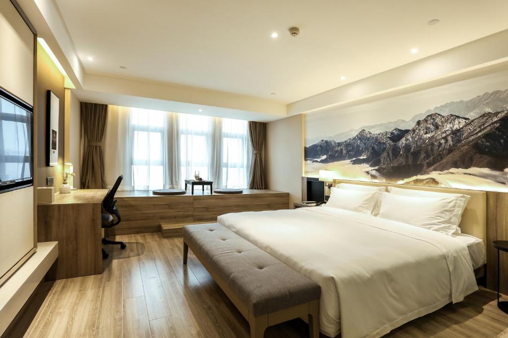 成都成都双流机场亚朵酒店的卧室配有一张白色大床和一张书桌