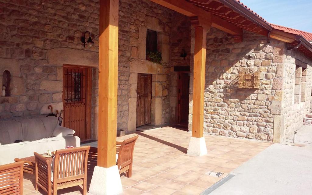 卡韦松·德·拉·萨尔Naturaleza playas y montañas的石头房子,设有门廊,配有沙发和椅子
