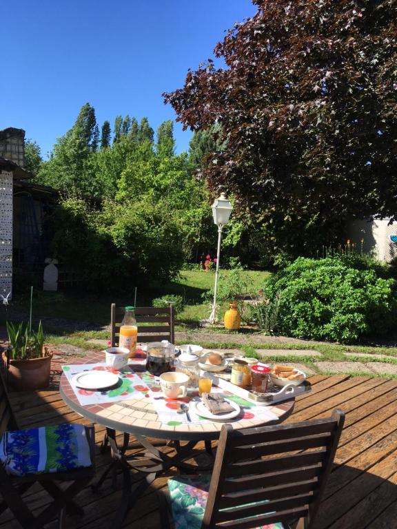 Avoinechambre sur jardin entre Fontevraud et RignyUssé的一张桌子,上面有食物,还有两把椅子