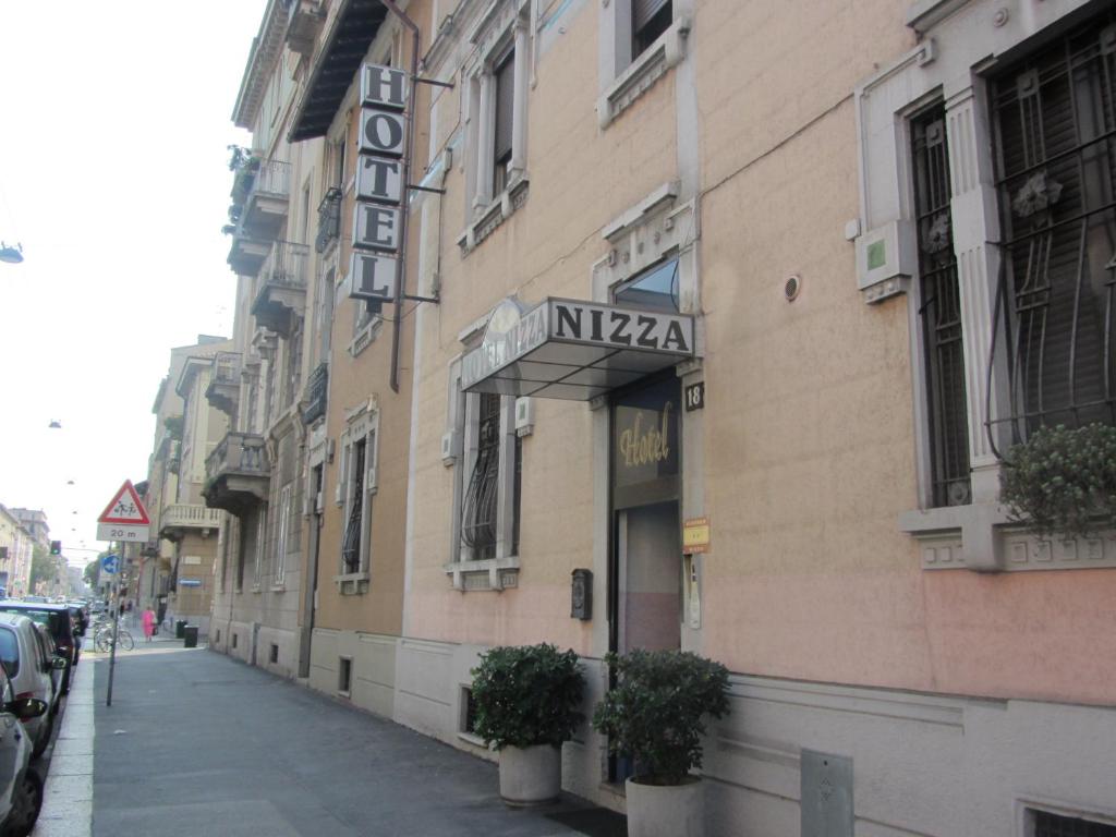 米兰尼萨酒店的街道边有标志的建筑物