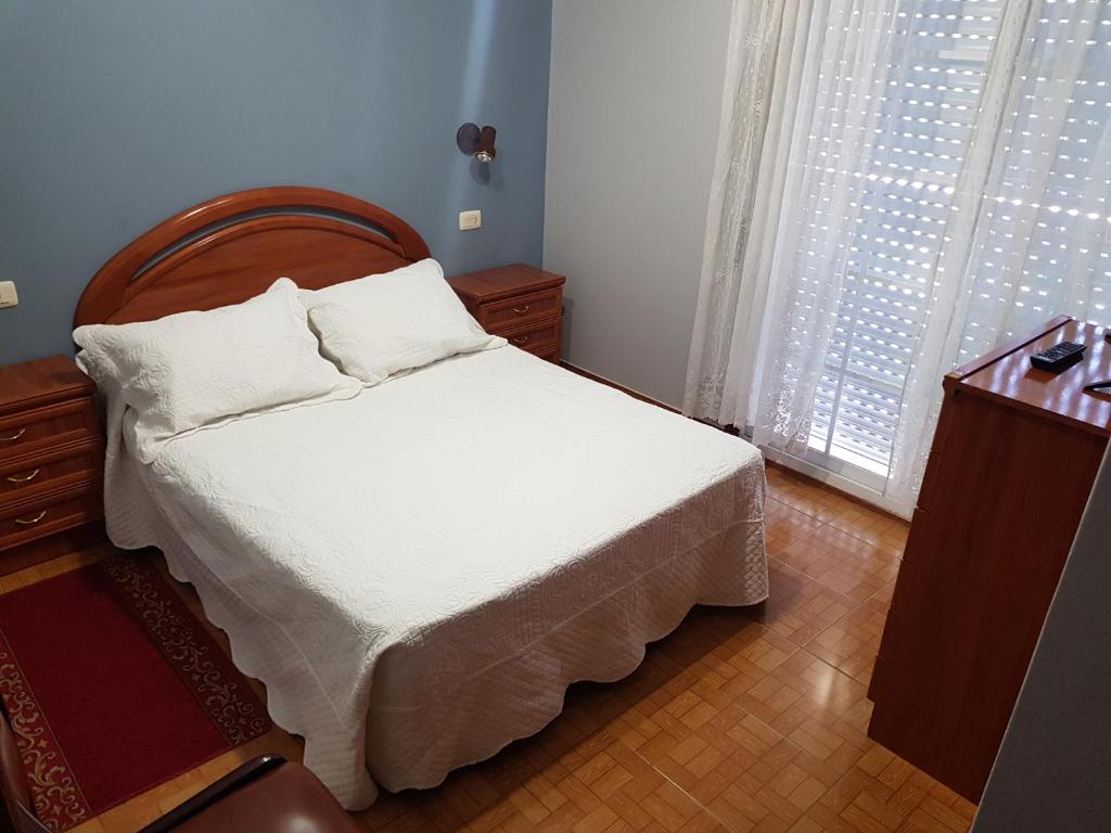 尼格兰Rincón Do Demo的一间卧室配有一张带白色床单的床和一扇窗户。