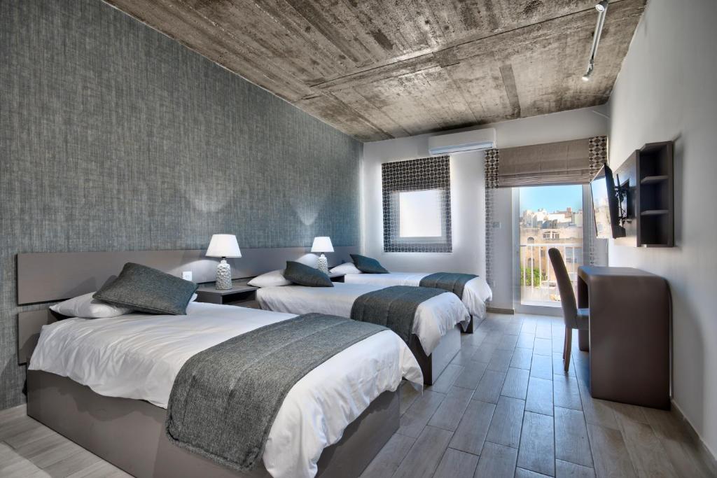 斯利马Cozy Rooms Hotel的一间卧室设有两张床、一台电视和一扇窗户。