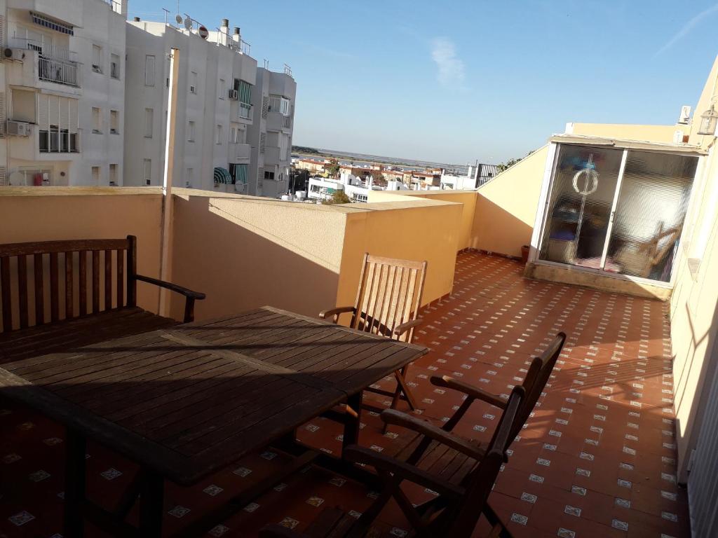 桑卢卡尔-德巴拉梅达Atico con espectacular terraza con vistas magníficas a la desembocadura del Guadalquivir的大楼内的阳台配有桌椅