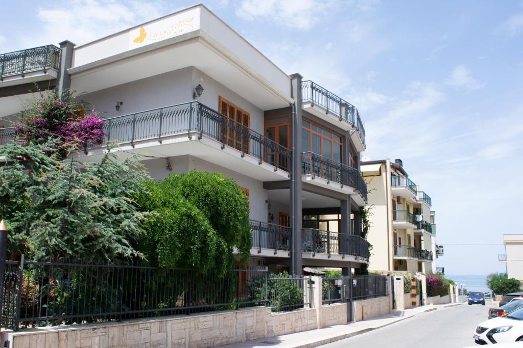 比谢列Villa Franca Mini Appartamenti的白色的建筑,在街上设有阳台