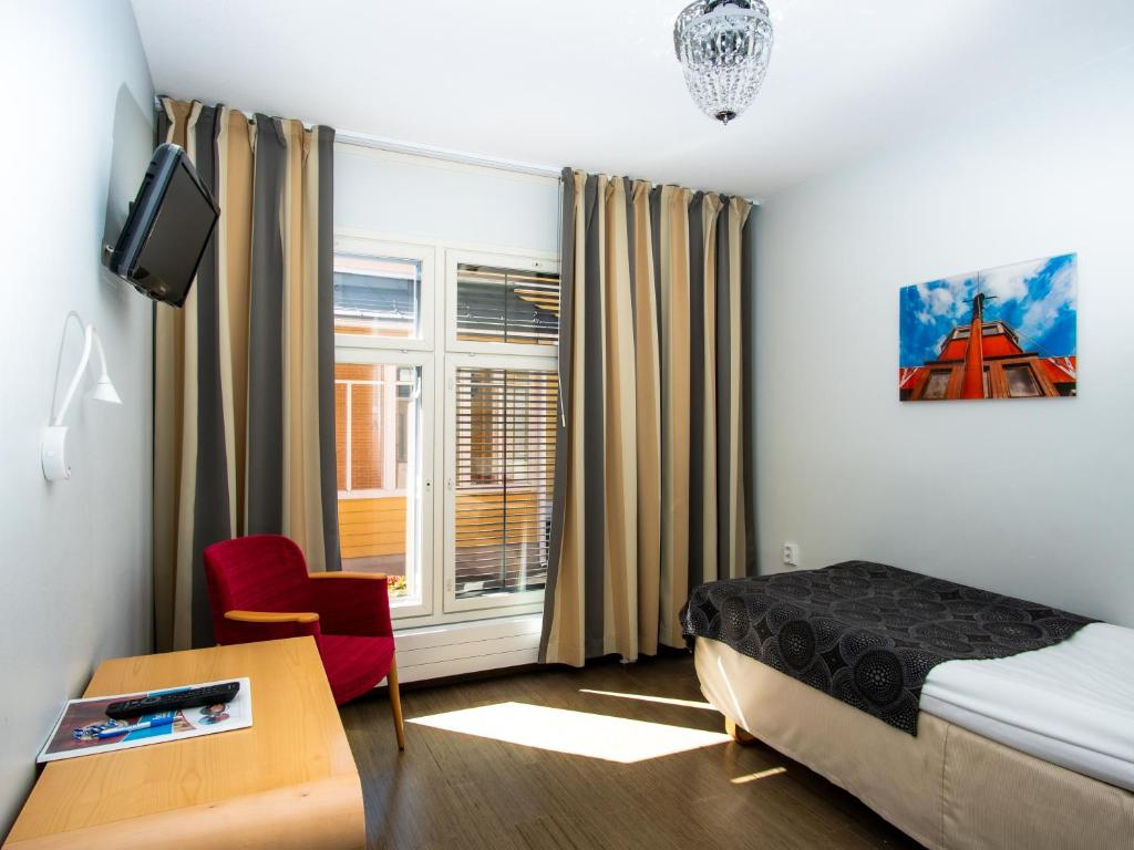 库奥皮奥Hotel Jahtihovi的一间卧室配有一张床、一张书桌和一个窗户。