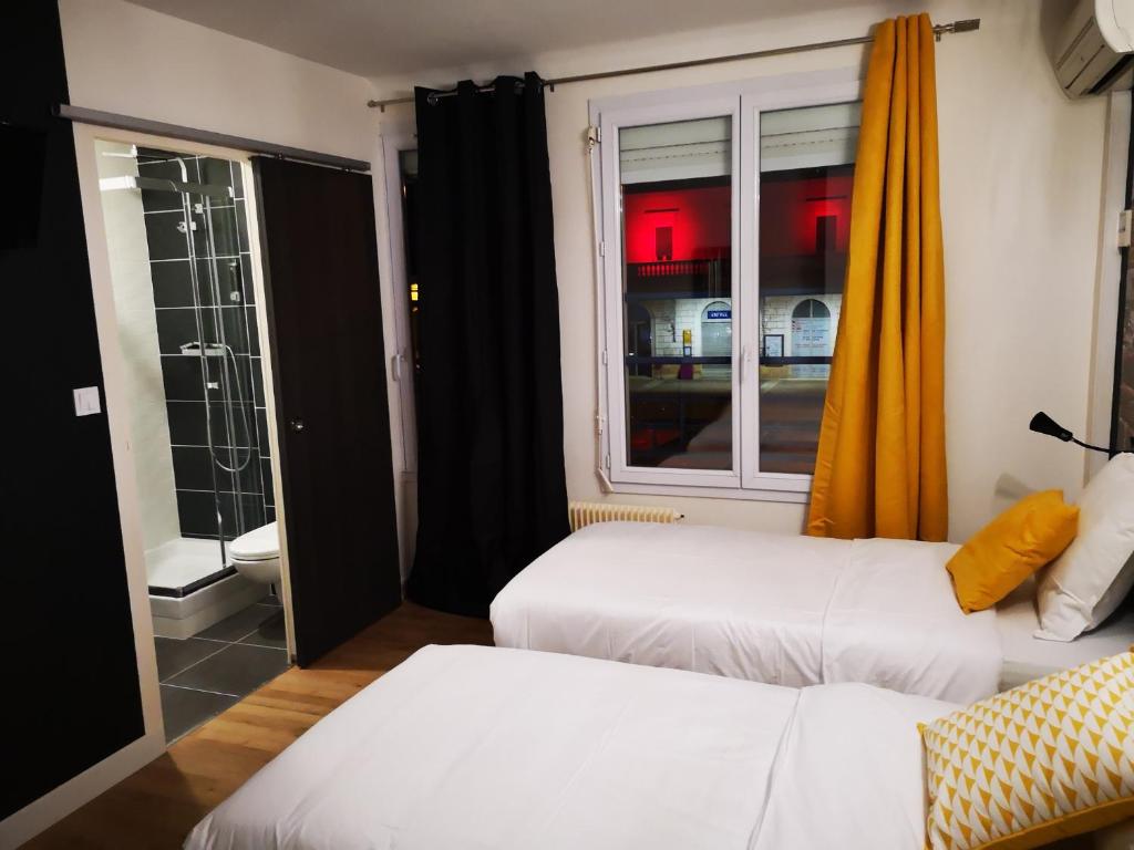 贝尔热拉克Hôtel Bar Brasserie L'ESCALE的酒店客房设有两张床和窗户。