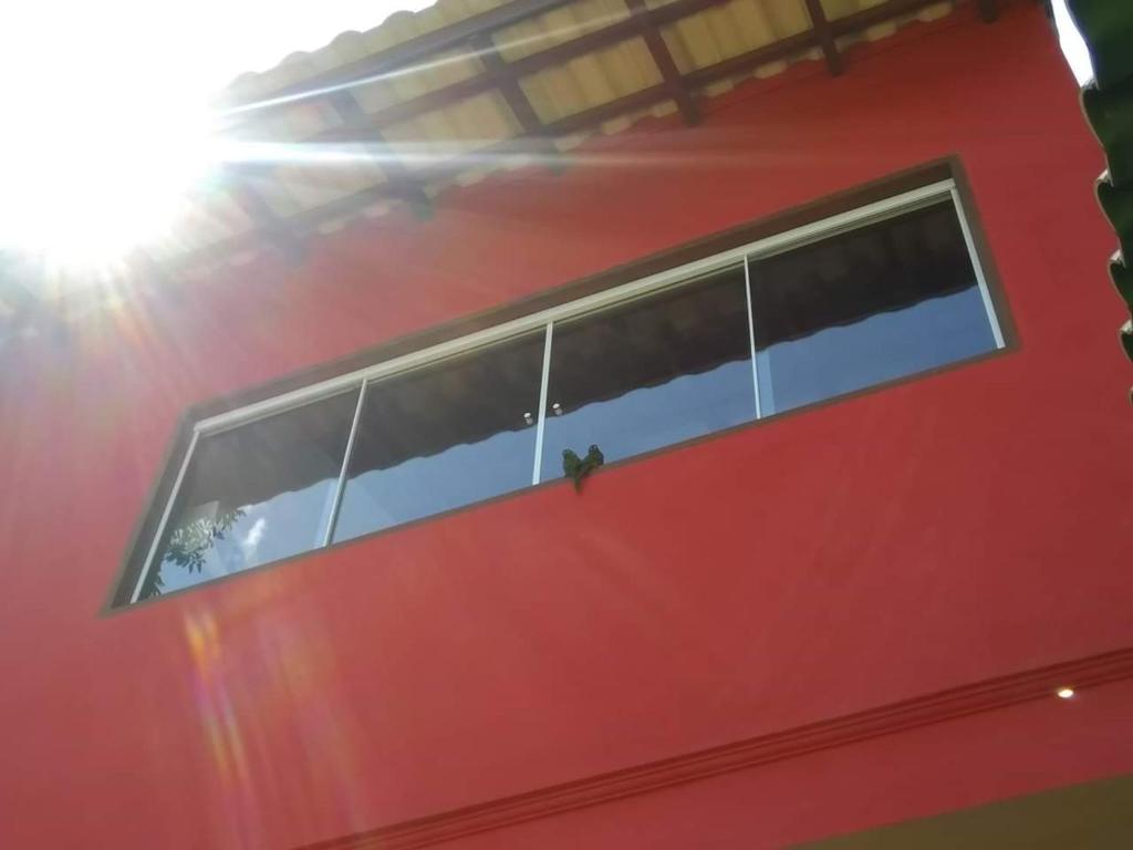 伊利亚贝拉Chalé da Katia的一座红色的建筑,上面有一排窗户
