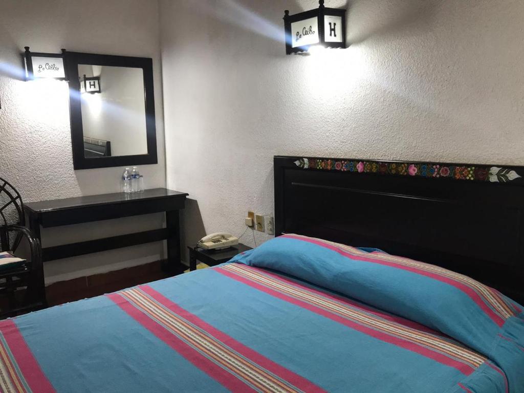 恰帕德科尔索Yaxché的一间卧室配有一张床、一个梳妆台和镜子