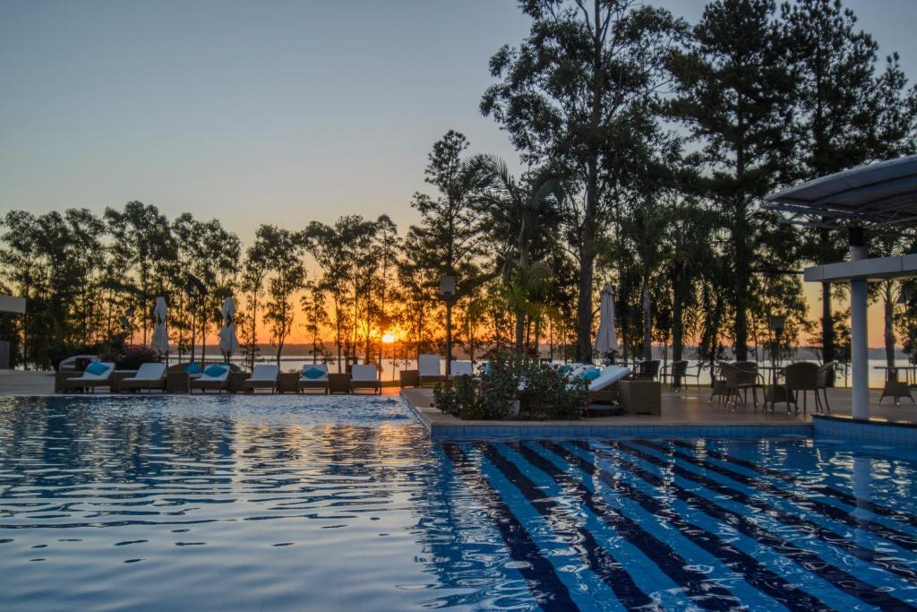 恩卡纳西翁阿瓦度假酒店的一座带椅子和树木的酒店游泳池