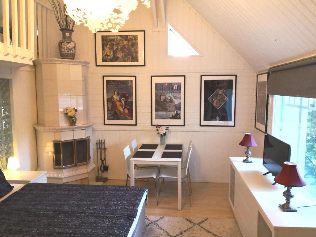 万塔Lovely Mint Garden Studio的客厅设有餐桌,墙上挂有图片