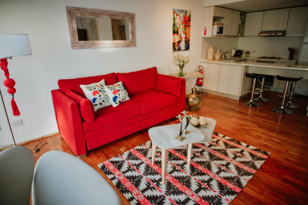 乌斯怀亚Ribera de Pipo Cálido departamento para tu estancia的客厅配有红色沙发和地毯。