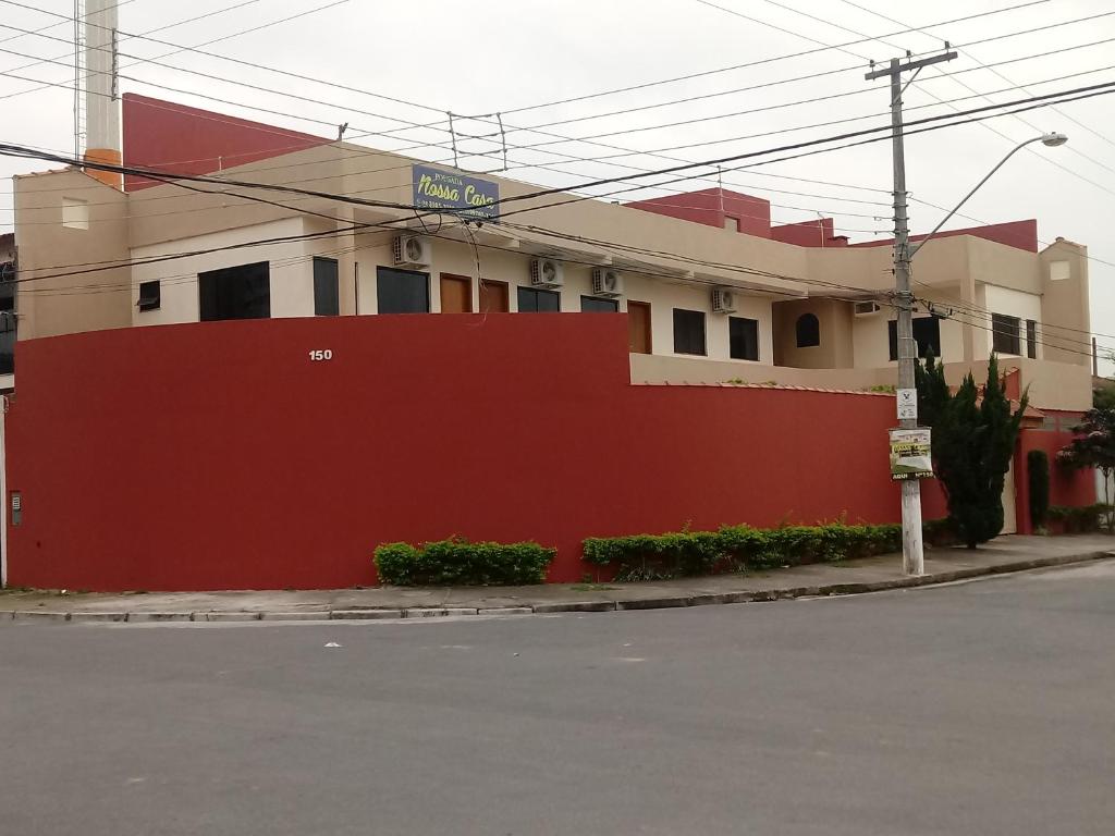 阿帕雷西达Pousada Nossa Casa的红色和白色的建筑,有红色的墙壁