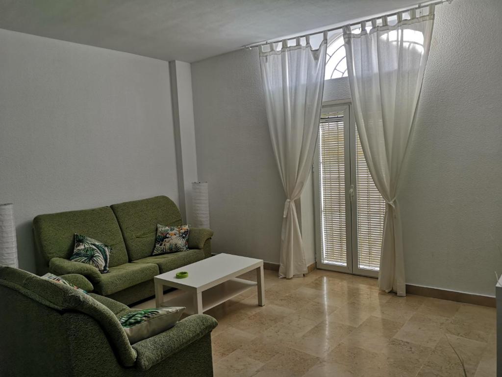 桑卢卡尔-德巴拉梅达apartamento princesa Leticia的带沙发、桌子和窗户的客厅