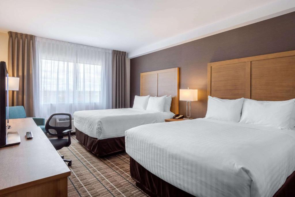 克拉伦维尔Quality Hotel的酒店客房配有两张床和一张书桌
