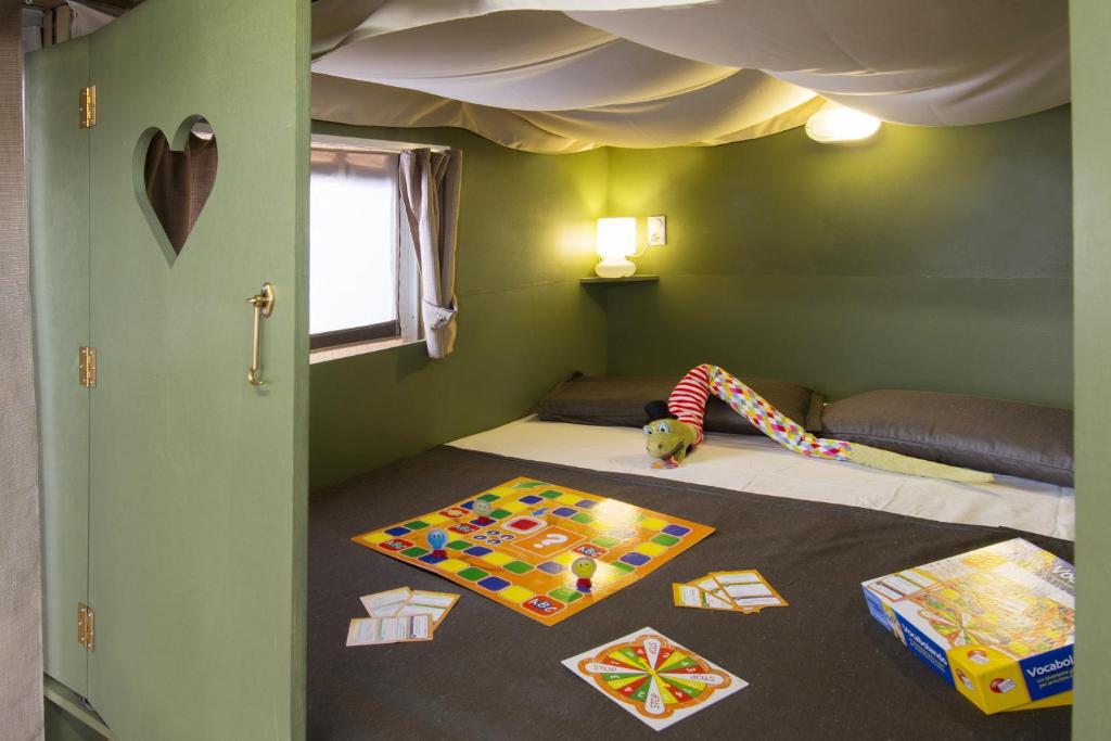 东塞斯特里Camping Mare Monti的一间房间,里面设有一张床,上面有孩子