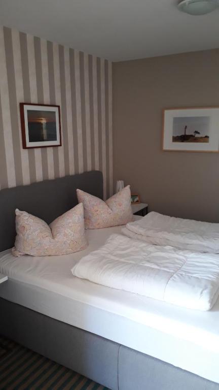 宾茨Fewo Kasch的一间卧室配有带白色床单和枕头的床。