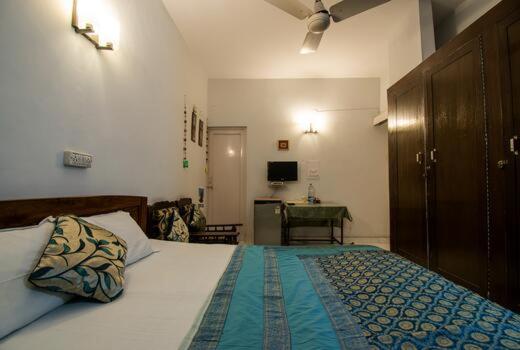 新德里Comfort Point Bed & Breakfast的一间卧室配有一张床和一张书桌