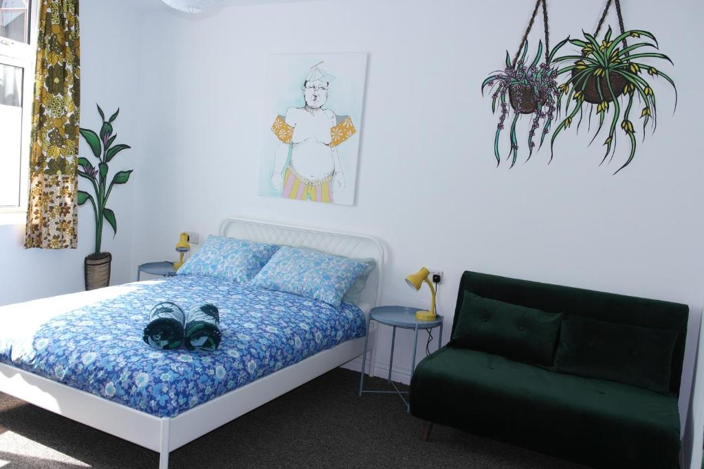 诺丁汉混合冰屋旅舍的一间卧室配有一张床和一张绿色沙发