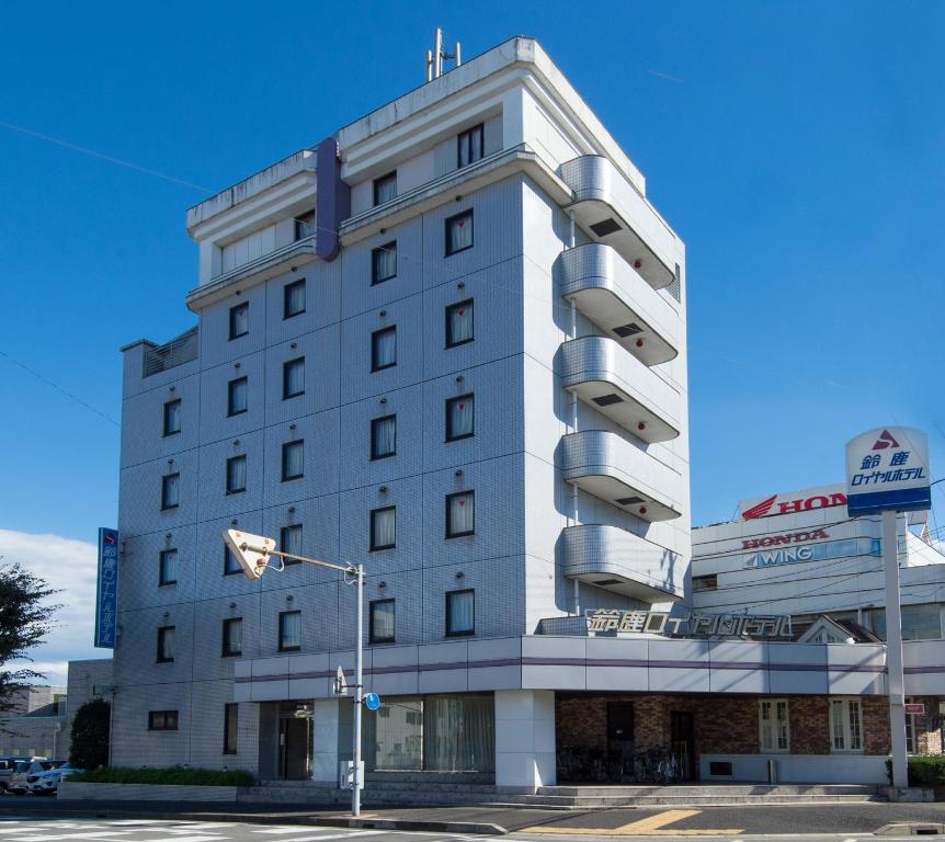 铃鹿市Suzuka Royal Hotel的白色的建筑,旁边标有标志