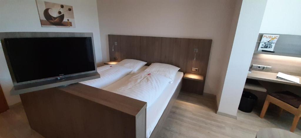 希尔德斯海姆Landgasthof Zur scharfen Ecke的一间卧室设有一张带平面电视的床。