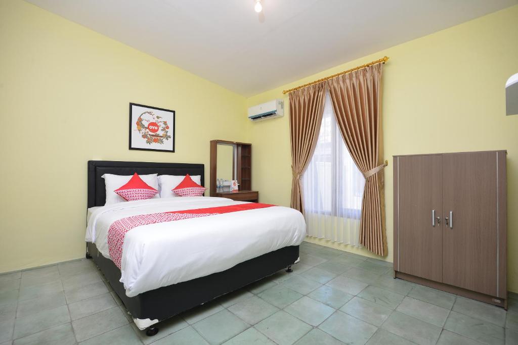 日惹Super OYO 1046 Omah Pathok的一间卧室设有一张大床和一个窗户。