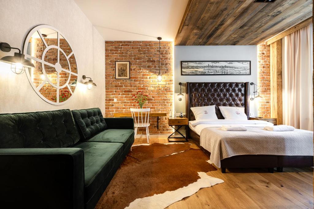 格但斯克哥特别墅酒店的一间卧室配有一张床和一张绿色沙发