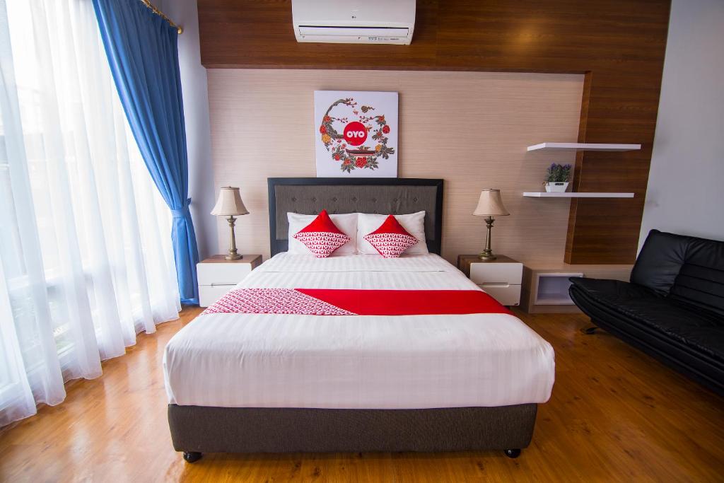 坤甸OYO 1097 Appartel Cempaka的一间卧室配有一张带红色枕头的大床