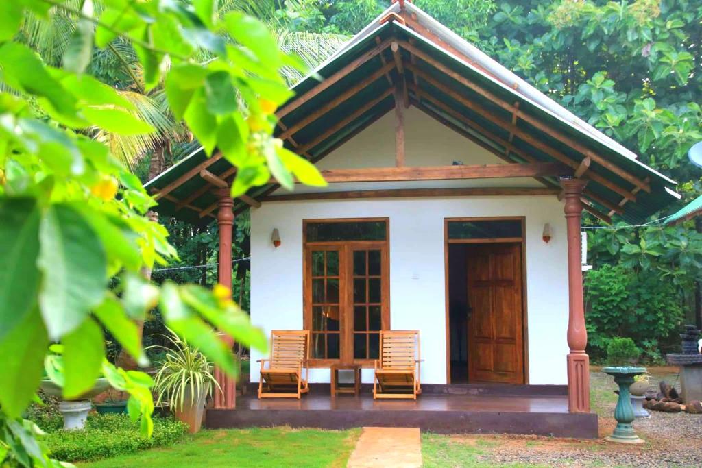 达瓦拉维翠景旅行度假旅馆的前面有两把椅子的小房子