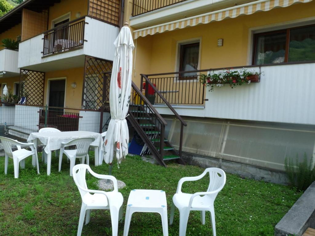 滕诺Appartamento Mora的一组白色的桌椅和一把伞