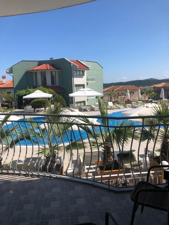 索佐波尔栀子度假公寓的享有带椅子和遮阳伞的游泳池的景色