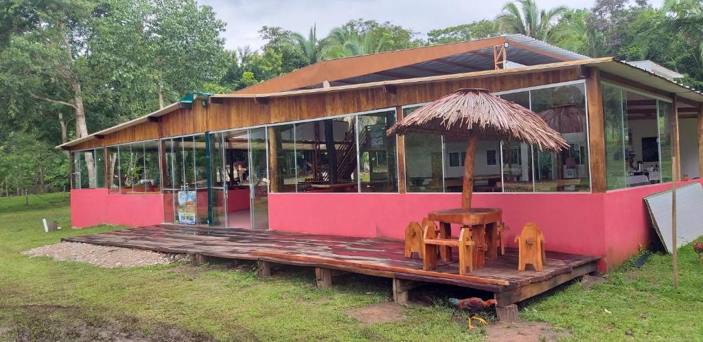 诺布里斯Estância Cyclo das Águas的粉红色的房子前面设有桌椅