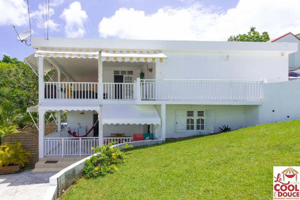 哥西尔Kouleur Karayib的带阳台和草坪的白色房屋