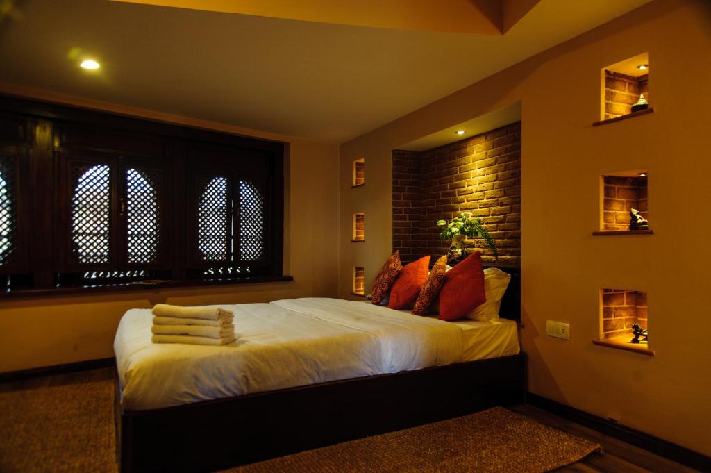 巴克塔普尔塔古晨精品酒店的一间卧室设有一张床和砖墙